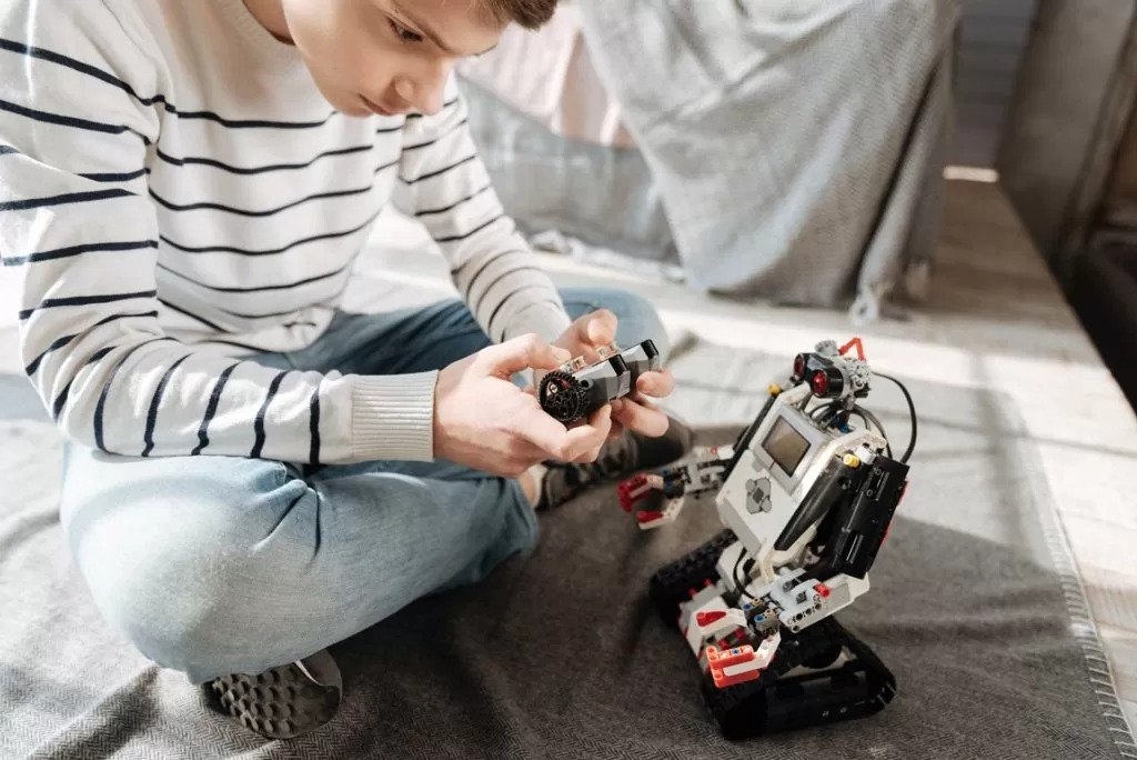 Boy plays with a robot toy that has a voice over